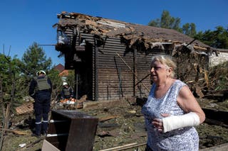 Local resident Lyudmila Tsinkush who was injured during a Russian drones strike on her house walks in her garden